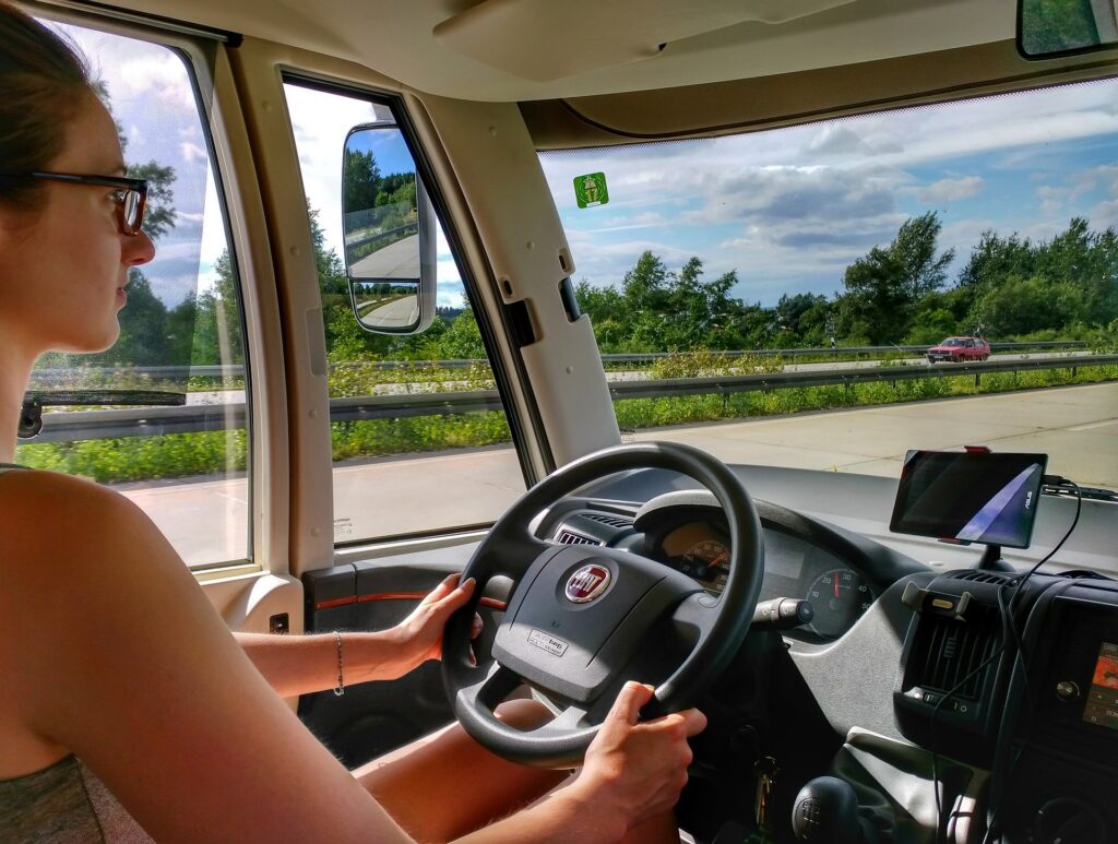 Mladá řidička za volantem automobilu jedoucího po víceproudé silnici