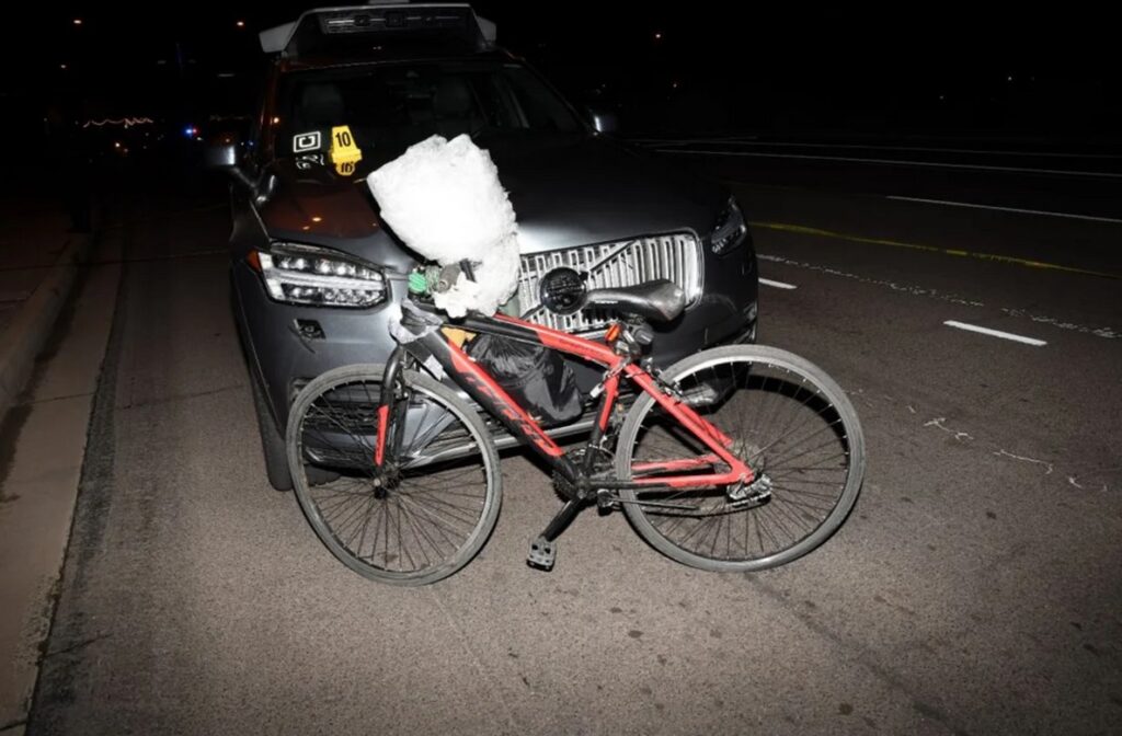 Jízdní kolo stojící na silnici před osobním vozidlem